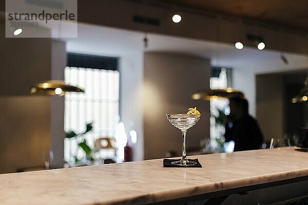 Cocktail in glass on illuminated at bar counter