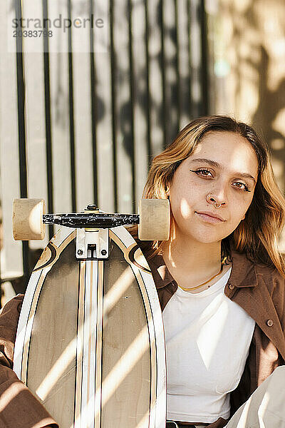 Portrait of young woman with skateboard