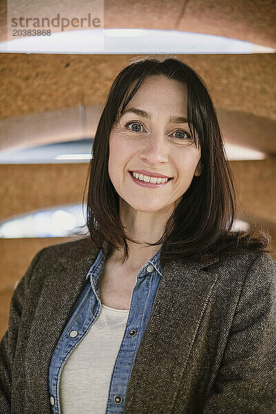 Smiling businesswoman wearing brown blazer