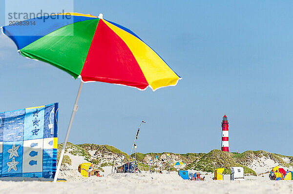 Germany  Schleswig-Holstein  Amrum  Sandy beach with colorful umbrella in foreground