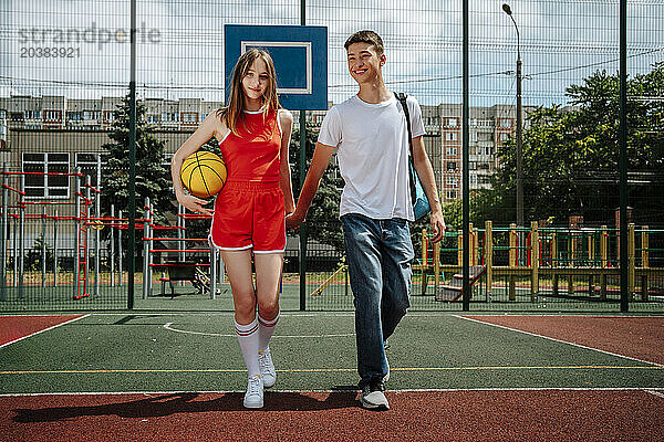 High school friends holding hands and walking in school yard