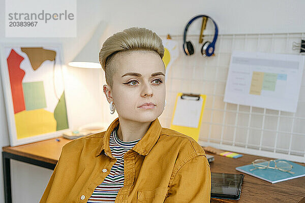 Thoughtful woman sitting near desk at home