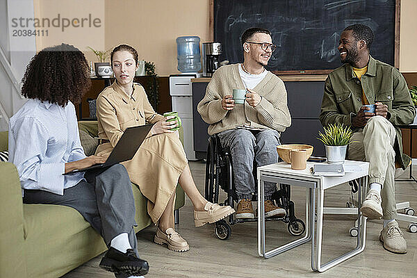 Happy multiracial business people having coffee break together in office