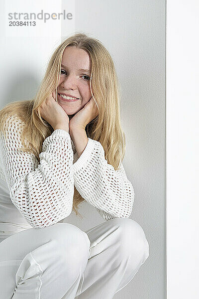 Teenage girl leaning on elbows against white background