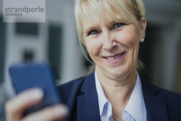 Smiling businesswoman with smart phone