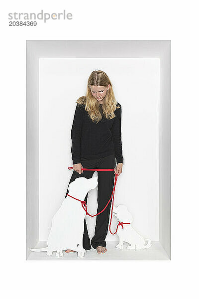 Blond girl with dog cut out standing against white background