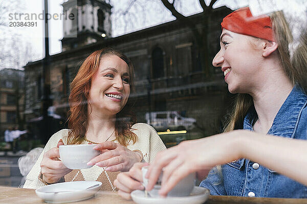 Happy friends having coffee together in cafe