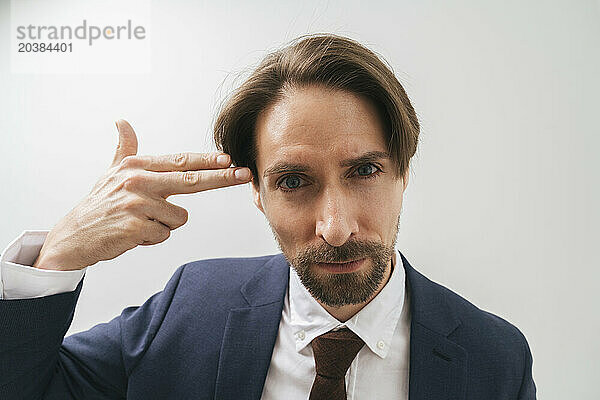 Businessman aiming at head against white background