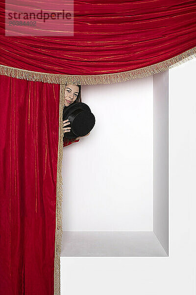 Teenager peeking from curtain in alcove