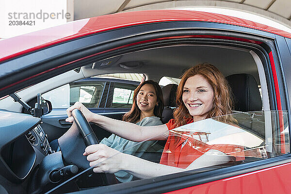 Smiling young friends traveling through car