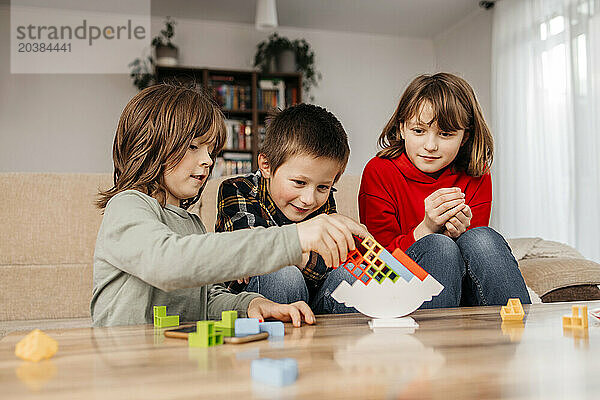 Siblings stacking blocks and playing at home