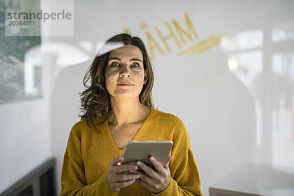 Creative businesswoman holding tablet PC in office