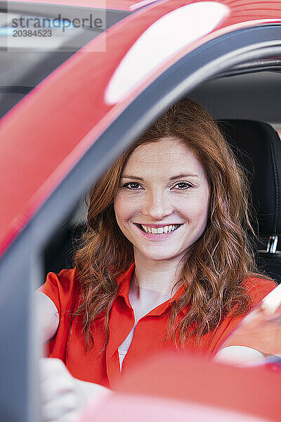 Smiling redhead woman in car