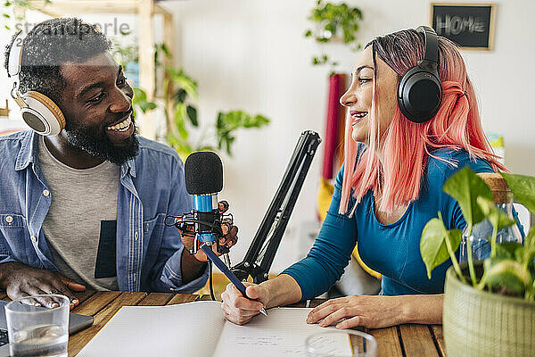 Happy influencers recording podcast together at home