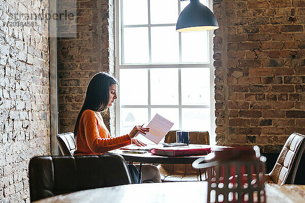 Young woman studying at restaurant