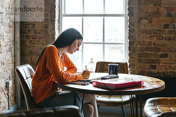 Young woman studying at coffee shop