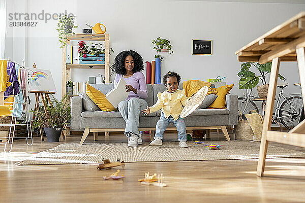 Toys on floor with mother and daughter in living room at home
