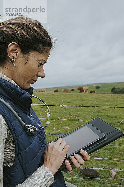 Veterinarian using tablet PC at farm