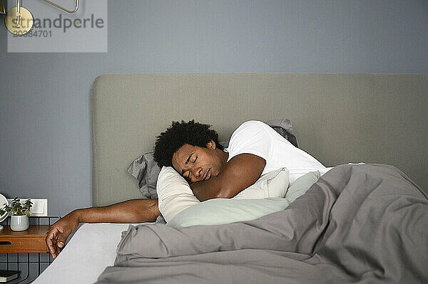 Man sleeping in bed at home