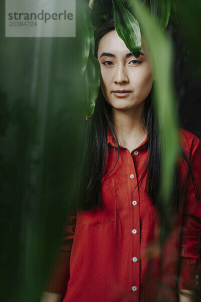 Young woman standing near plants