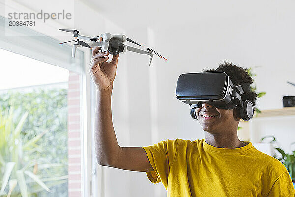 Teenage boy in VR glasses learning to operate drone