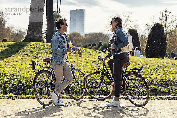 Couple standing and talking near bicycles on footpath