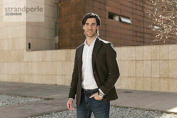 Confident businessman in blazer on footpath