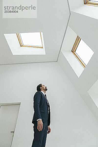 Businessman looking at window in office