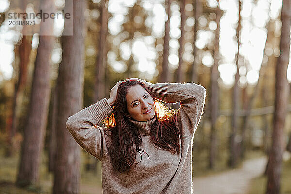 Smiling woman with head in hands at park