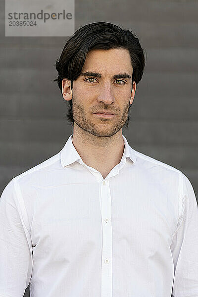 Confident young businessman in white shirt