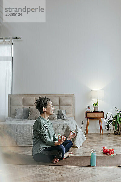 Woman doing yoga on exercise mat at home