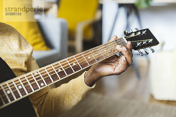 Senor man playing guitar at home