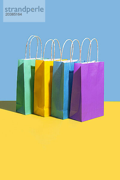 Multi colored shopping bags against colored background