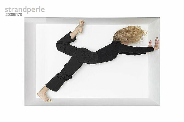 Blond teenage girl leaning on alcove against white background