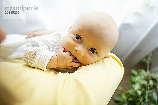 Cute boy with mother by window at home