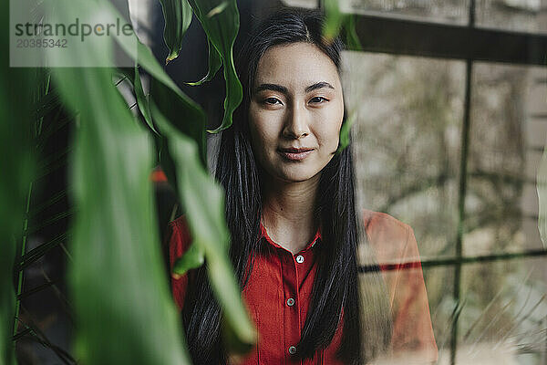 Young woman photographed through glass window