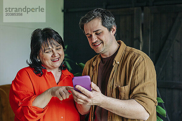 Happy mother and son using smart phone together at home