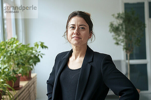 Confident businesswoman wearing black blazer at home office