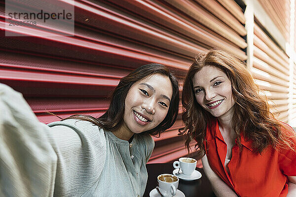 Young friends taking selfie near shutter