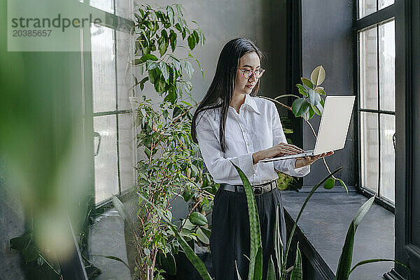 Young businesswoman working on laptop in office