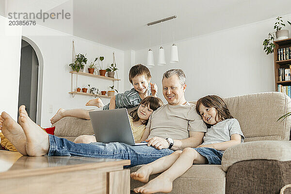 Happy family watching movie on laptop at home