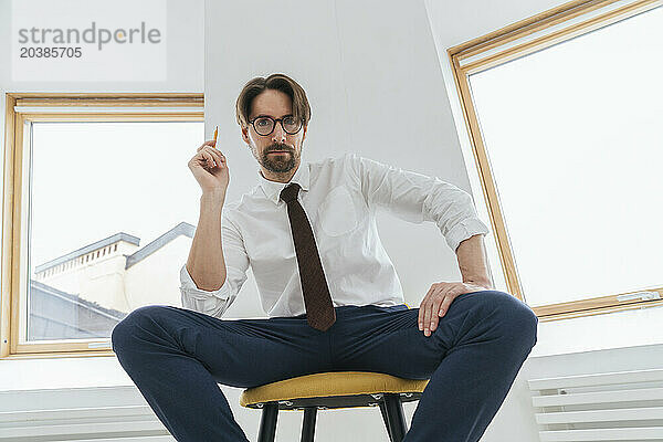 Confident businessman sitting on chair in office