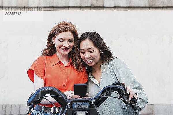 Smiling friends renting electric bicycle at station