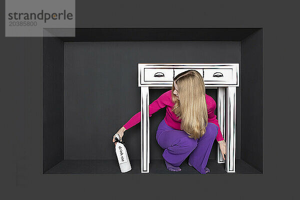 Teenager with spray bottle sitting below table in alcove