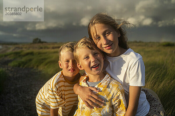 Blond siblings embracing in nature