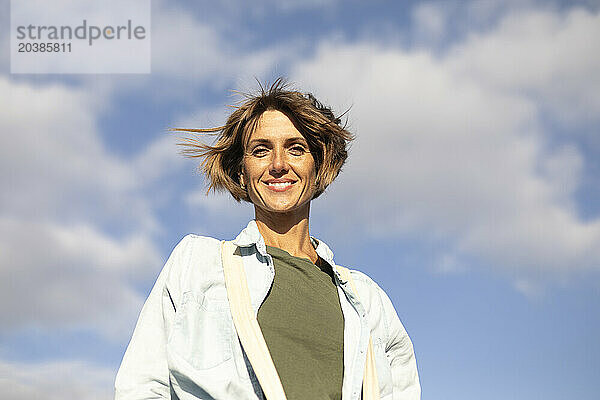 Smiling mature woman under sky