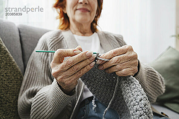 Retired woman knitting at home