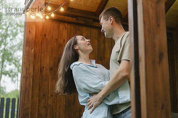 Romantic couple looking at each and embracing on porch