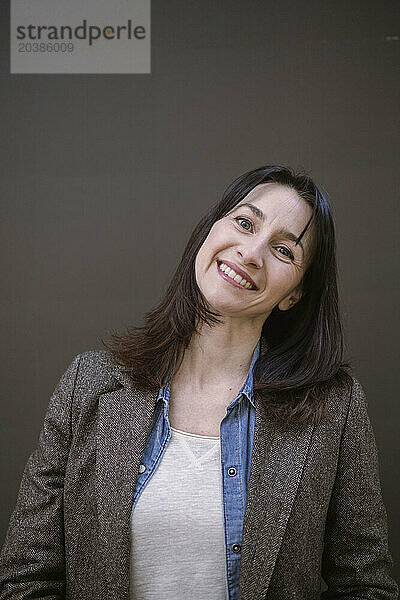 Smiling businesswoman against brown background