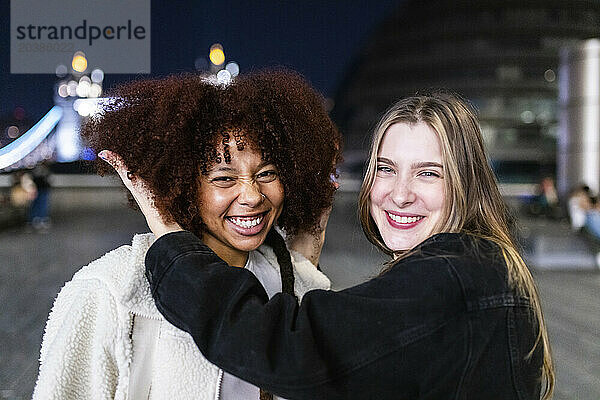 Happy young friends enjoying in London City at night
